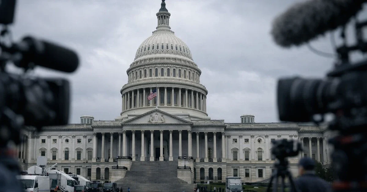 The exterior of the United States Capitol building on an overcast day, captured in a professional news-style wide shot with a serious, political atmosphere.