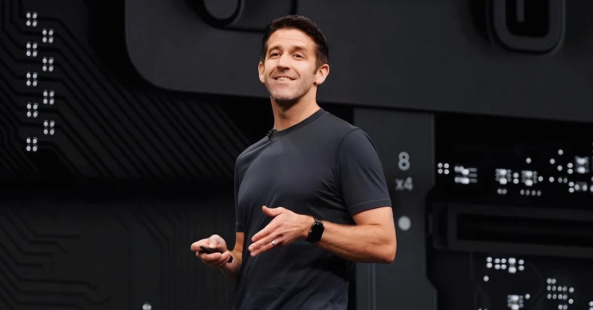A professional male tech executive standing in a modern corporate office, representing the future leadership of a major technology company.